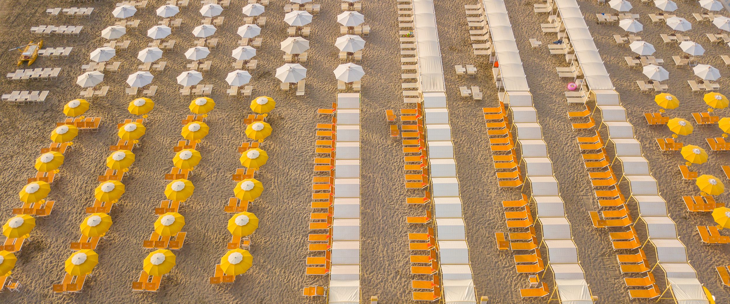 the beach in Rimini with yellow sun loungers and parasols